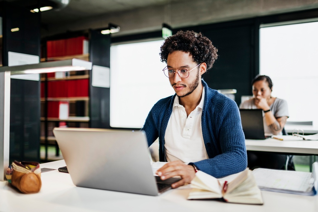Frau sitzt am Tisch und prüft Rechnungen